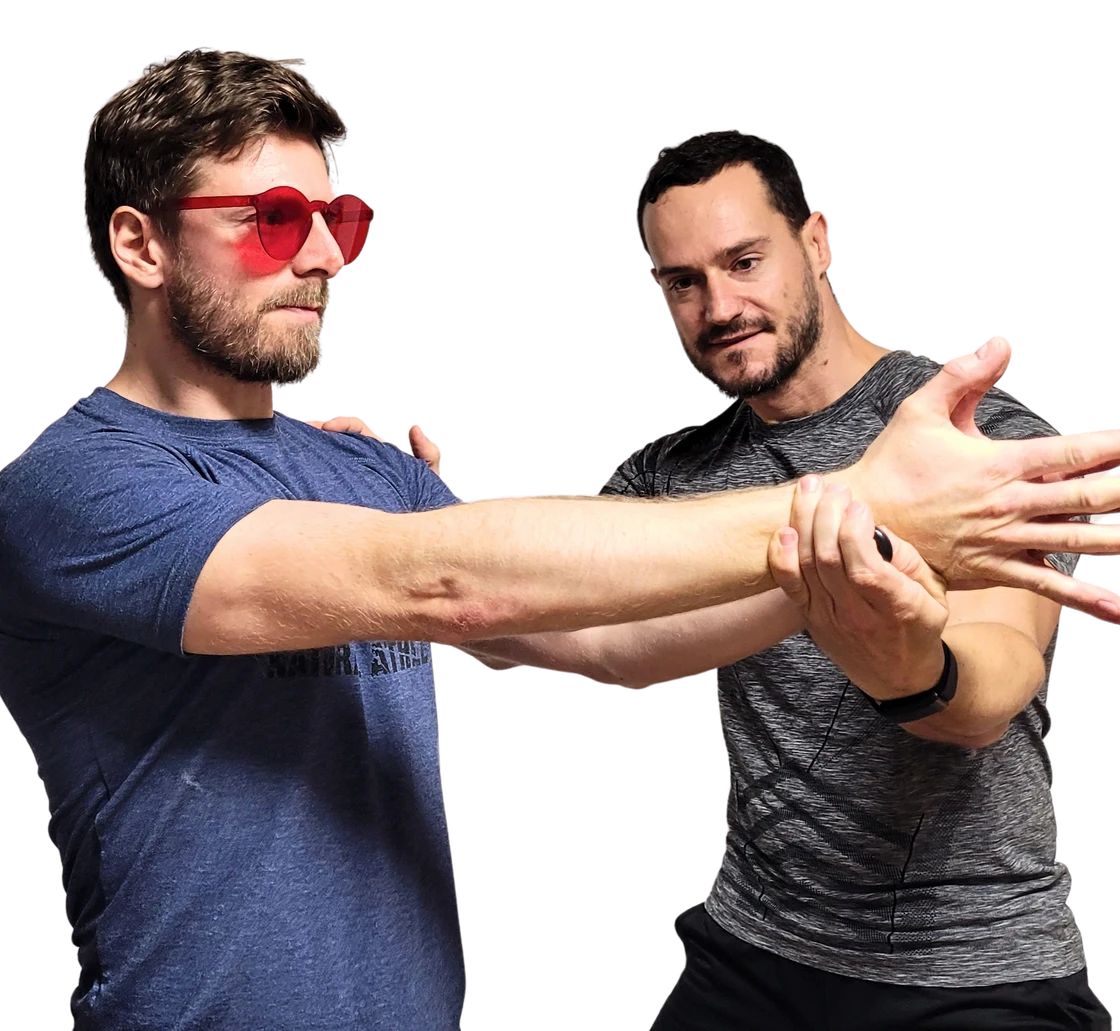 Tino prüft den Unterarm eines Klienten mit roter Brille in einer praktischen Betreuungssituation